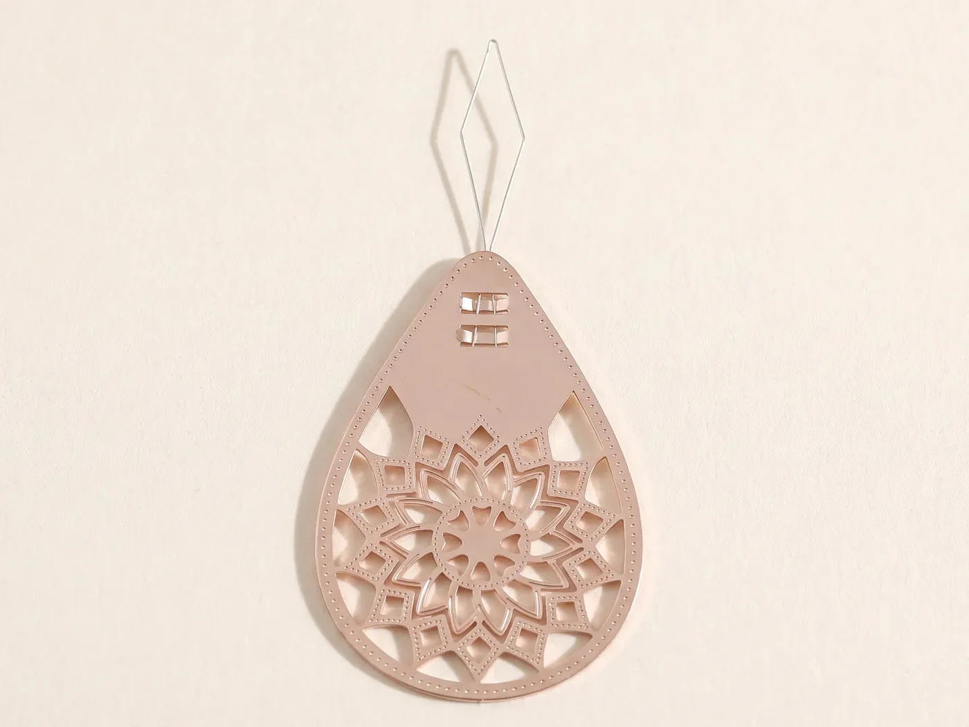 Enfile-aiguille fleur et sa boucle métallique sur papier clair